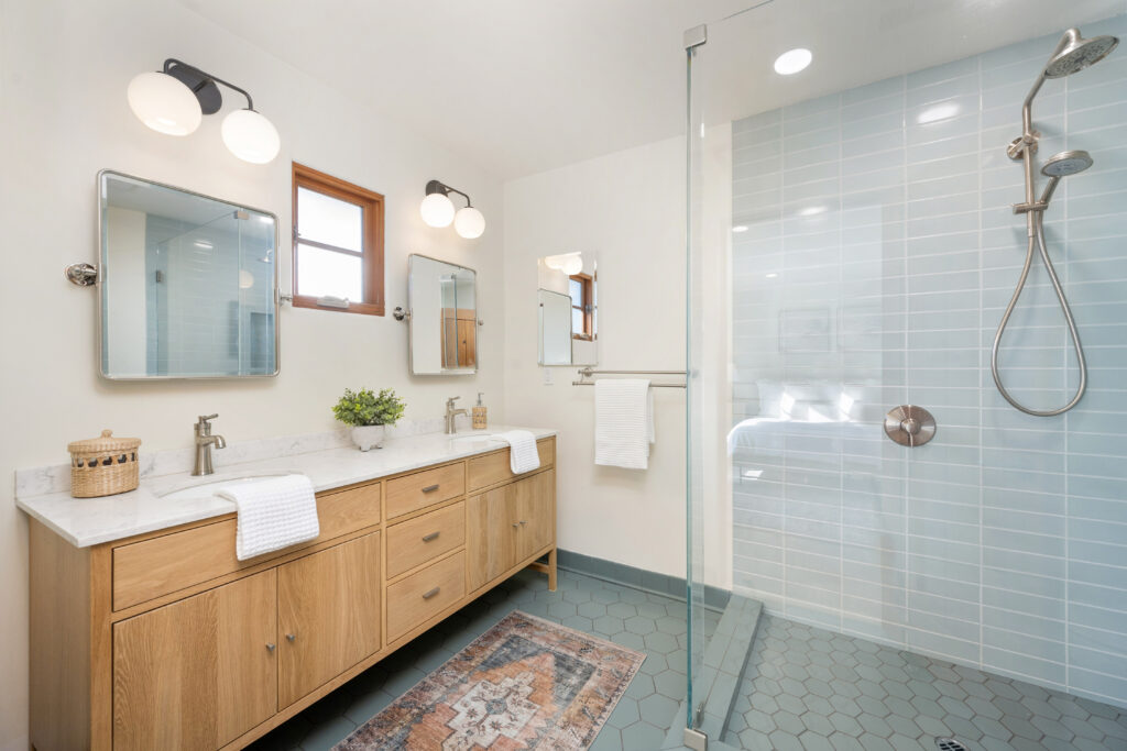 White bathroom with tiled walls, wooden cabinets, and sky blue tiled floor