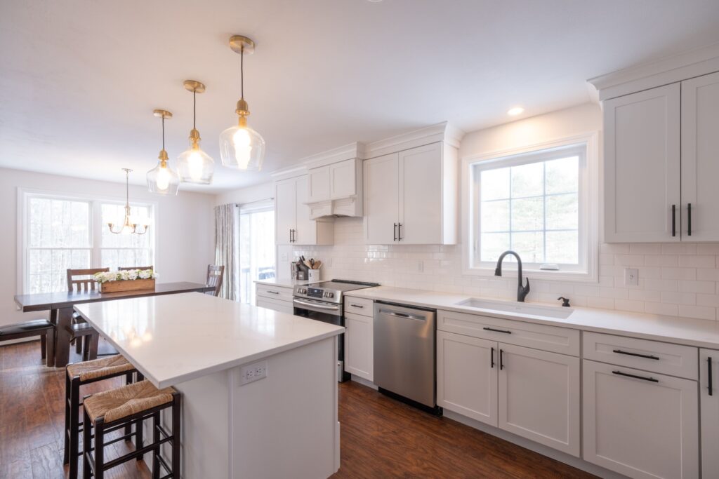 Modern white kitchen interior with an oven, sink, faucet, a wooden cabinet and table