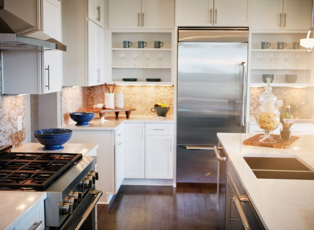 Modern kitchen with new appliances, wood flooring, quartz countertops and modern decor